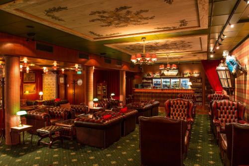 a bar with brown leather chairs and a bar counter at Victory Hotel in Stockholm