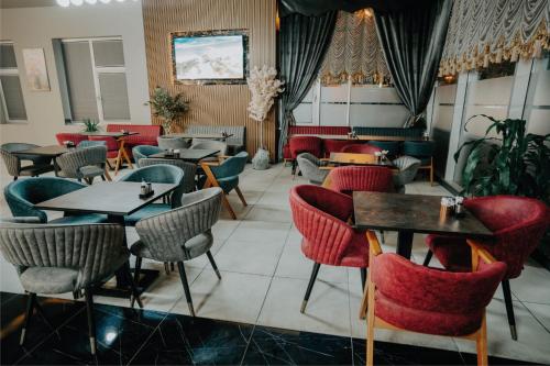 un restaurante con mesas y sillas en una habitación en Grand Quars Hotel, en Avcılar