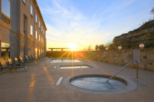 a hot tub outside of a building with the sun setting at Baymont Inn & Suites by Wyndham Glen Rose in Glen Rose