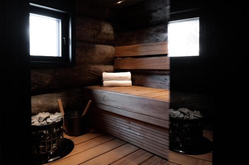 una sauna con bañera de madera y 2 ventanas en Villa Lake Ruka, en Ruka