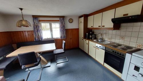 uma cozinha com uma mesa de madeira e uma bancada em Ferienwohnung Juen em Sankt Gallenkirch