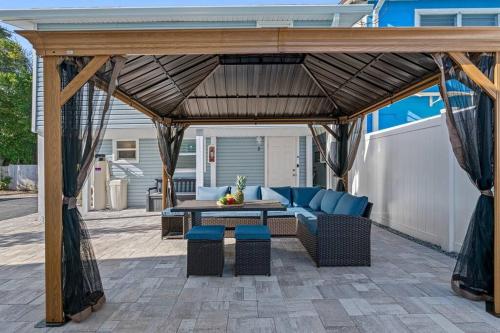 a gazebo with a couch and a table on a patio at Welcome to Cozy Coastal Cottages of Dunedin #1 in Dunedin