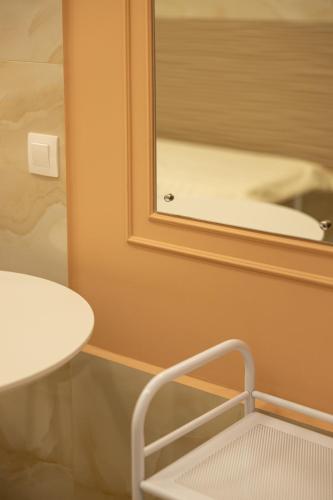 a bathroom with a mirror and a table and a chair at Медовий двір in Rozhanka Nizhnyaya
