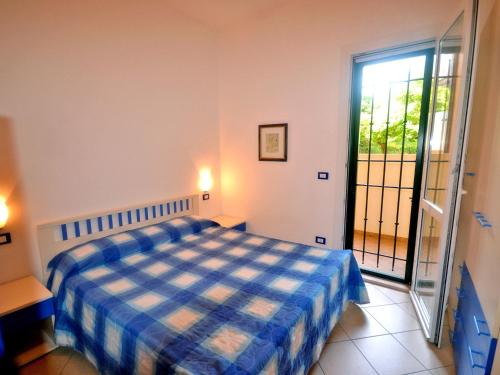 リド・デッレ・ナツィオーニにあるAmerica Appartamento Piano Terraのベッドルーム(青と白のベッド1台、窓付)