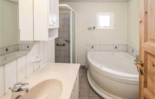 Baño blanco con bañera y lavamanos en Awesome Home In Sams With Wifi, en Nordby