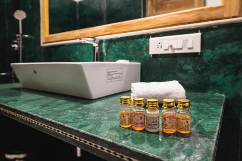 4 botellas de aceites esenciales sentadas en un mostrador en un baño en Hotel Meri Haveli, en Jaisalmer
