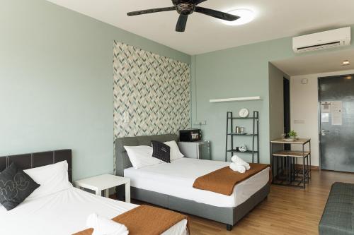 Cette chambre comprend deux lits et un ventilateur de plafond. dans l'établissement The WILLOW, Studio Cityview by WStay @ Tropicana 218 Macalister, à George Town