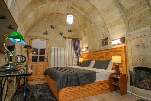 a bedroom with a bed in a room with a fireplace at Bala Cave House in Avanos