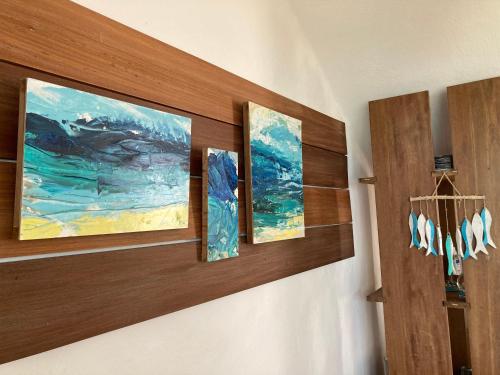 a room with three paintings on a wall at BlueMoon Villa - Authentic, seaside living in Trou dʼ Eau Douce