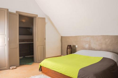 a bedroom with a bed with a yellow blanket at BlueMoon Villa - Authentic, seaside living in Trou dʼ Eau Douce