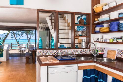 a kitchen with a sink and a view of the ocean at BlueMoon Villa on The Beach in Trou dʼ Eau Douce