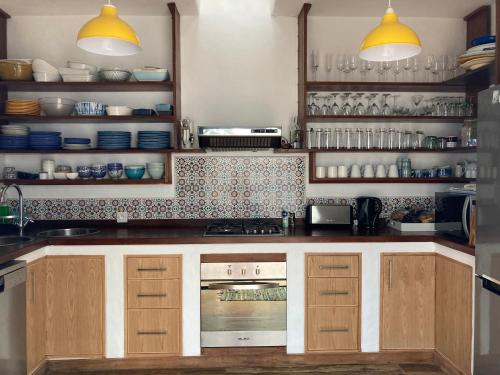 a kitchen with wooden cabinets and a stove top oven at BlueMoon Villa - Authentic, seaside living in Trou dʼ Eau Douce