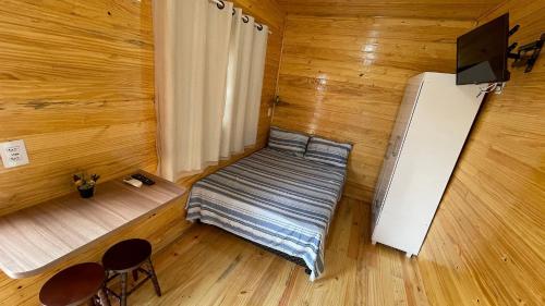 um pequeno quarto com uma cama e um frigorífico em Lindos e novos Chalés na região central de Foz em Foz do Iguaçu