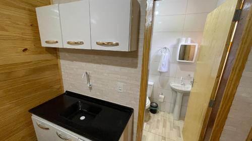 um pequeno banheiro com uma pia e um vaso sanitário em Lindos e novos Chalés na região central de Foz em Foz do Iguaçu