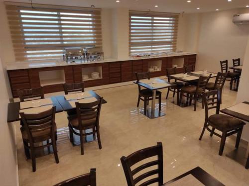 un restaurante con mesas, sillas y una barra en AQABA COAST HOTEL en Áqaba