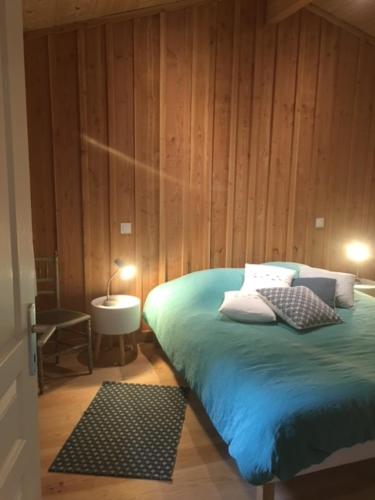 1 dormitorio con 1 cama, 1 mesa y 1 lámpara en Cabane Chic au Cap Ferret, en Lège-Cap-Ferret