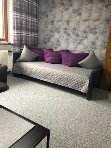 a couch with purple pillows in a living room at Haus Hubertus Sommerpreise incl Sommercard in Jerzens