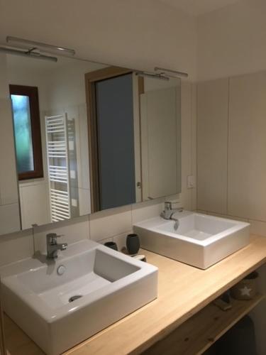 łazienka z 2 umywalkami i dużym lustrem w obiekcie Cabane Chic au Cap Ferret w mieście Lège-Cap-Ferret