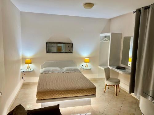 a bedroom with a bed and a desk and a chair at Artemisia Apartment Caldera in Imerovigli