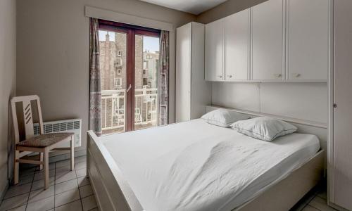 um quarto com uma cama, uma cadeira e uma janela em Korre 0302 em Koksijde