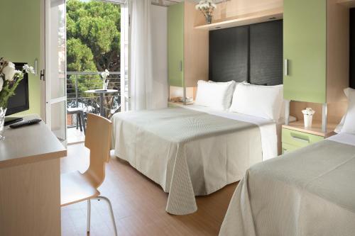 a hotel room with two beds and a balcony at Hotel Sampaoli in Bellaria-Igea Marina