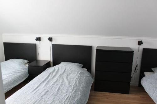 a bedroom with two beds and a dresser at Äppelgården in Sollebrunn