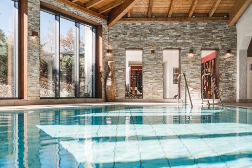 a swimming pool in a house with a brick wall at Parkhotel am Soier See in Bayersoien