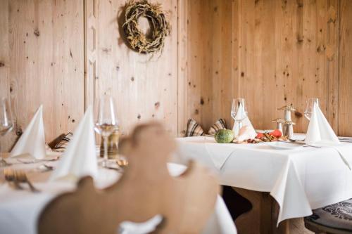 a dining room with two tables with white table cloth at Parkhotel am Soier See in Bayersoien