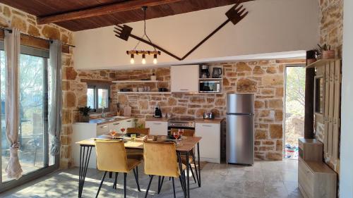 a kitchen with a table and chairs and a refrigerator at Vila Apostolis in Agios Pavlos
