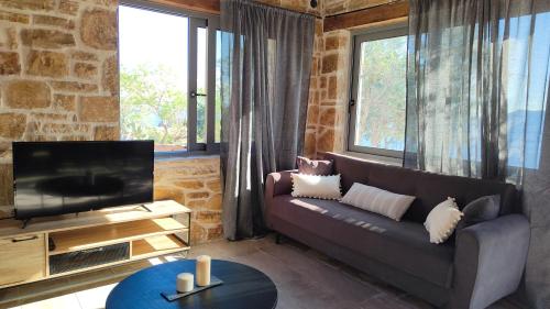 a living room with a couch and a television at Vila Apostolis in Agios Pavlos
