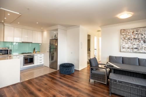 a kitchen and living room with a couch and a table at Jade Resorts Melbourne in Melbourne