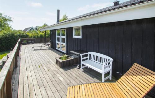 a wooden deck with a bench on a house at 2 Bedroom Nice Home In Samsø in Nordby