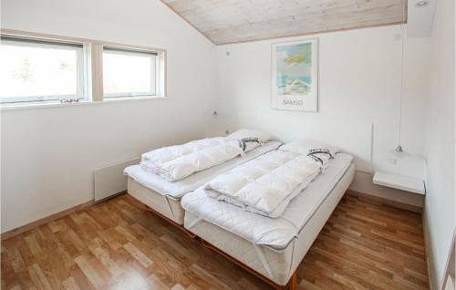 a bedroom with a bed with white sheets and pillows at 2 Bedroom Nice Home In Samsø in Nordby