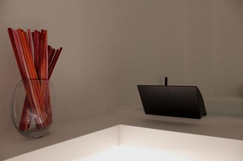 a vase with sticks in it sitting next to a monitor at Archimar House in Taranto