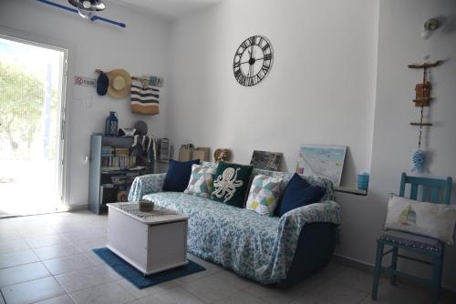a living room with a couch and a clock on the wall at Relaxing and Comfortable Studio Near Falasarna Beaches in Plátanos