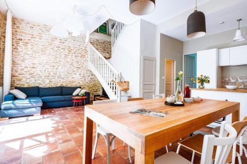 Il dispose d'une cuisine et d'un salon avec une table et des chaises en bois. dans l'établissement L'Aparté, gîte avec piscine, à Valréas
