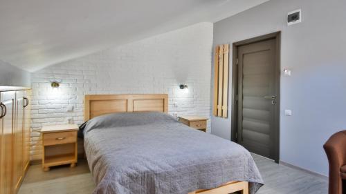 a bedroom with a bed and a white brick wall at Casa Zânelor Slănic Moldova in Slănic-Moldova