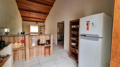 a kitchen with a white refrigerator in a room at Casa Sabiá - Lençóis/BA in Lençóis