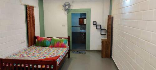 una habitación con un banco con almohadas de colores. en Wind &Waves, en Kollam
