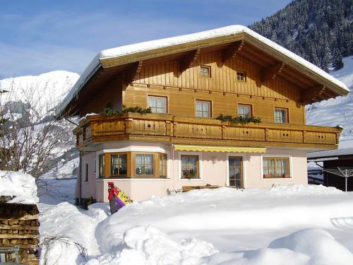een groot houten huis met sneeuw ervoor bij Haus Manuela sonnige Aussicht mit Bergpanorama inkl NATIONALPARK CARD in Rauris