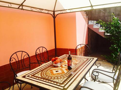 einen Tisch mit einer Flasche Wein und einer Schale Obst in der Unterkunft Etna Dimora Dei Saponari in Trecastagni