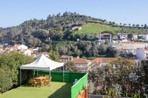 a patio with a white tent and chairs and a city at High Villa in Alenquer