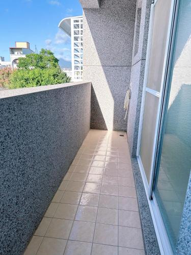 a balcony with a glass door and a tile floor at Happy Fat B&B 寵物友善 in Taitung City
