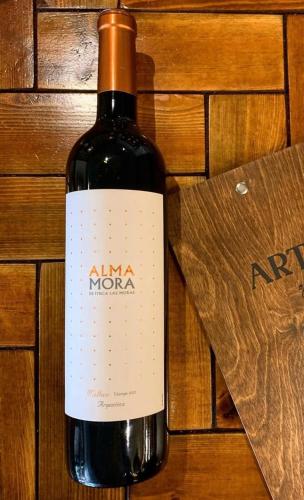 a bottle of wine sitting on a wooden table at Arthur's Bar & Accommodation in Southport