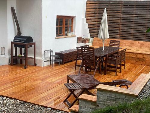 a wooden deck with a table and chairs and a grill at wundervoll eben - CHALETS & PLÄTZE voller WUNDER - NOTSCHKERL & FEINIS in Waasen