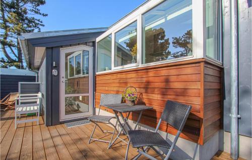 a tiny house with a table and chairs on a deck at Gorgeous Home In Samsø With Kitchen in Nordby