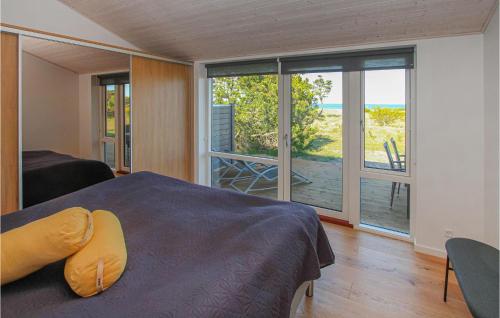 a bedroom with a bed and a view of a deck at Gorgeous Home In Samsø With Kitchen in Nordby