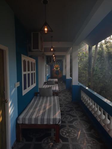 a room with three beds in a room with a window at Unearth Hostel (Pondicherry) in Auroville