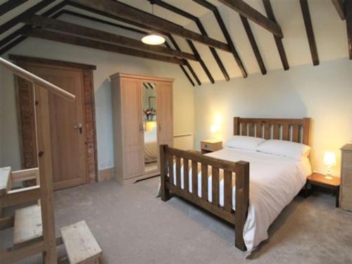 a bedroom with a large bed and a staircase at The Old Dairy in rural sea side location in Norwich