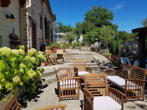 a group of chairs and tables on a patio at La Perle Secrète in Theneuille